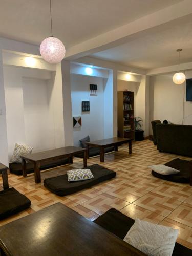 een woonkamer met tafels en een bank bij Zoola Suites Antigua in Antigua Guatemala