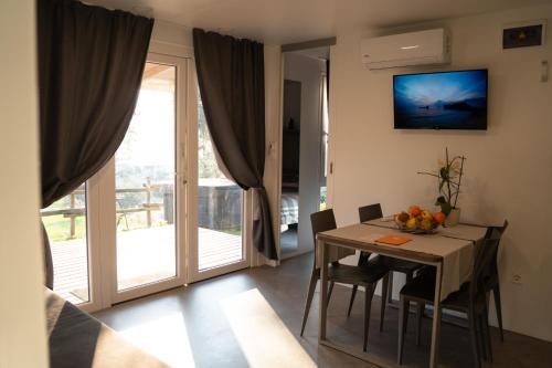 a dining room with a table and a sliding glass door at Agricamping Est Garda Home Rubino in Lazise