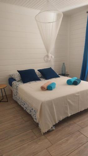 una camera da letto con un letto con cuscini blu di Villa Tilo a Sainte-Anne