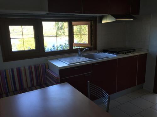a kitchen with a sink and two windows at Camping Village Stella Mare in Lacona