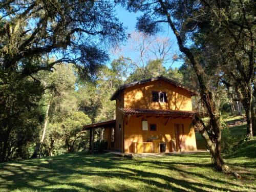 a house in the middle of a field with trees at Rio Privativo, Piscina e Starlink - Casa Terras de Minas in Gonçalves