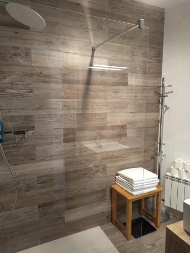 a bathroom with a shower with a wooden wall at Ramon del Xalet in Ibars de Noguera