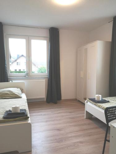 a small bedroom with two beds and a window at Burgweg Living in Bad Wildungen