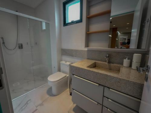 a bathroom with a toilet and a shower and a sink at Infinity Tower Flat 1105 in Itapema