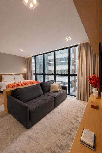 a living room with a couch and a bed at Infinity Tower Flat 1105 in Itapema