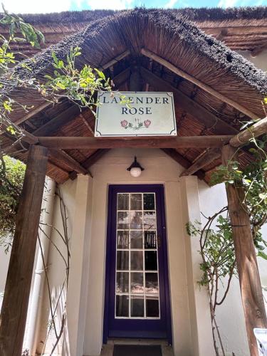 een huis met een bord erop bij The Little Thatch Cottage in Greyton