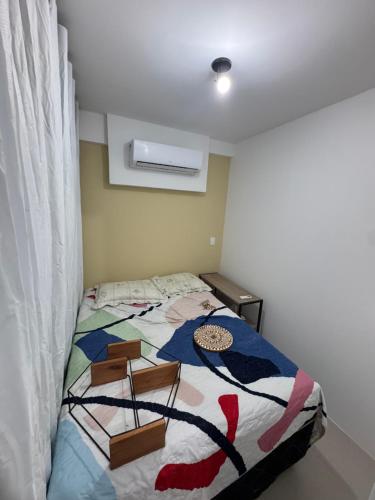 een slaapkamer met een bed met een kleurrijk dekbed bij Rooftop Carneirinho in Tamandaré