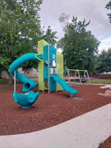 a playground with a blue slide in a park at Lavender Cottage - Cute & Cosy Miner's Cottage in Ballarat