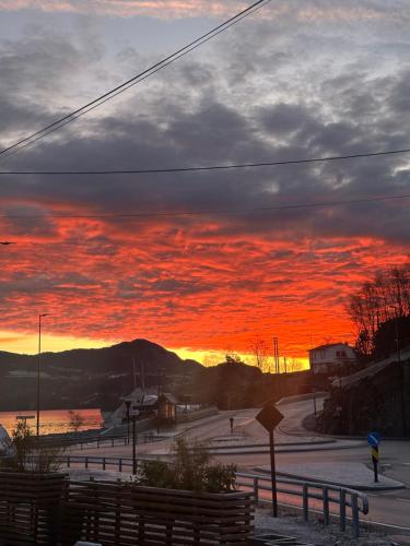 een zonsondergang boven een met sneeuw bedekt veld met een rode lucht bij Aurora Bliss - Fjordfront Jacuzzi & Sauna near Bergen in Askøy