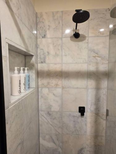 a bathroom with a shower with a glass door at A Sweet Studio for One in Altona