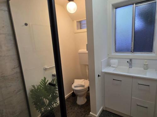 a bathroom with a toilet and a sink and a window at A Beachside Villa with Vogue Verve in Altona