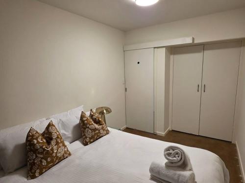 a bedroom with a white bed with pillows and a closet at A Beachside Villa with Vogue Verve in Altona