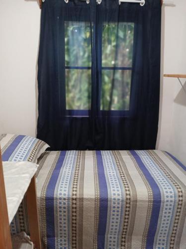 een bed in een kamer met een raam bij Casa Amarela in Bocaina de Minas
