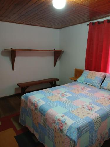 a bedroom with a bed with a colorful quilt at Casa Amarela in Bocaina de Minas