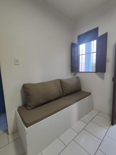 een bank in een kamer met een raam bij Jacuípe House in Camaçari