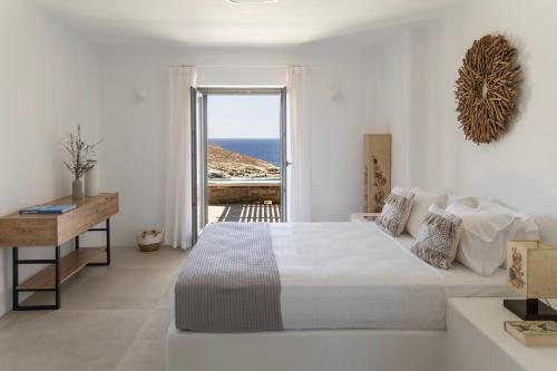 une chambre blanche avec un lit et une vue sur l'océan dans l'établissement Villa Glaronisi Kea, à Otziás