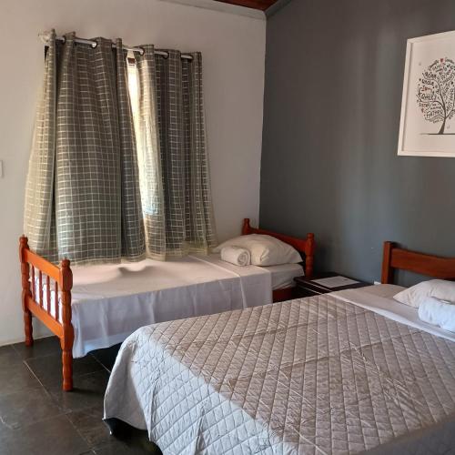 En eller flere senge i et værelse på Dharma Pousada