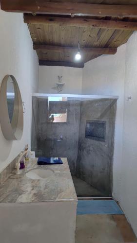 a bathroom with a sink and a mirror at Paraiso Beach House in Santa Cruz Cabrália