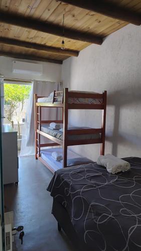 a bedroom with two bunk beds and a window at Paraiso Beach House in Santa Cruz Cabrália