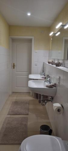 a bathroom with three sinks and a toilet at Ferienwohnung Bachklang Oberprechtal in Elzach