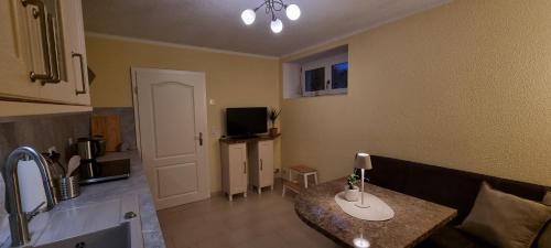 een kamer met een keuken met een tafel en een televisie bij Ferienwohnung Bachklang Oberprechtal in Elzach