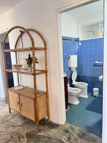 a bathroom with a room with a toilet and a shelf at Itamar Lodge in La Coronilla