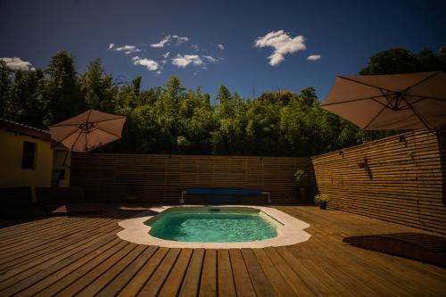 een klein zwembad met twee parasols op een terras bij Ambar Posada Boutique in Aiguá