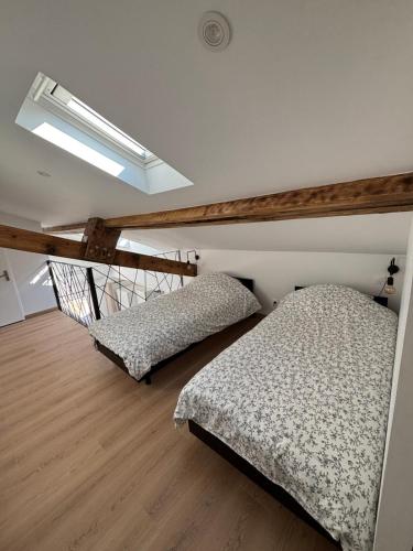een slaapkamer met twee bedden en een dakraam bij Studio in Amblagnieu