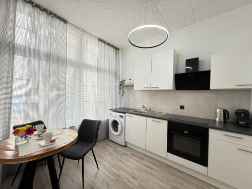 een keuken met witte kasten, een tafel en een magnetron bij Time Wohnung in Wuppertal
