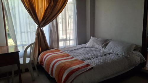 a bed in a room with a window at Cabaña el Rincon Del Lago in Paipa