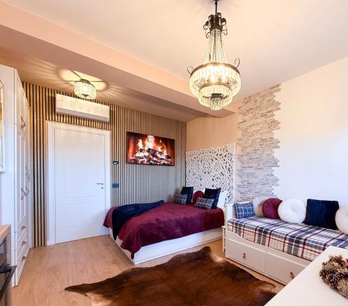 a bedroom with a bed and a couch and a chandelier at FORTUNA ORO in montagna in Spormaggiore