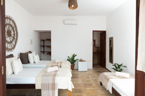 two beds in a room with white walls at Kitenest in Itarema