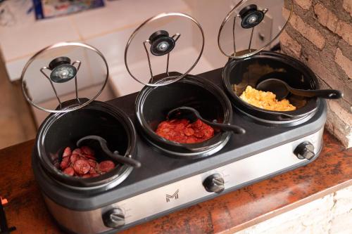 four pots of food on top of a stove at Kitenest in Itarema