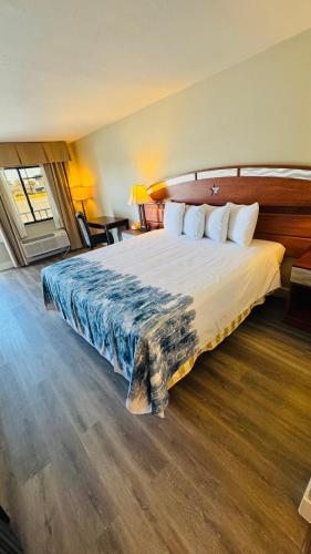 a bedroom with a large bed with a wooden headboard at Hotel Monte Carlo in Kissimmee