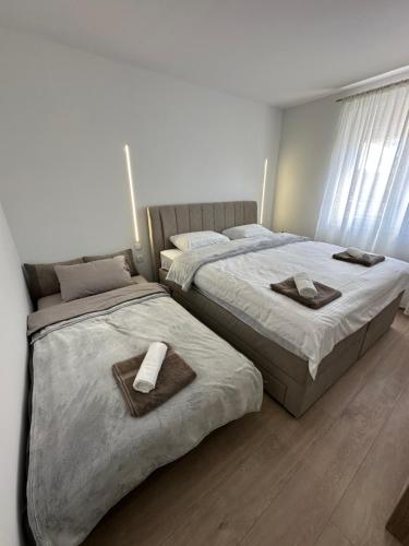 two beds in a bedroom with towels on them at Apartman Centar - Posušje in Posušje