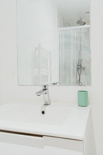 un lavandino da bagno con specchio e tazza blu di Le Quai 06 a Le Havre