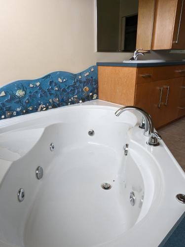a white bath tub in a bathroom with a sink at Argo's Landing in Bamfield