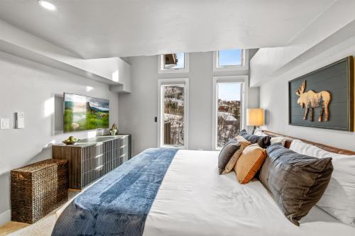 a bedroom with a large bed and a tv at Bear Claw 402 - Premier Ski-in Ski-out & Winter Shuttle! Renovated 2025! in Steamboat Springs