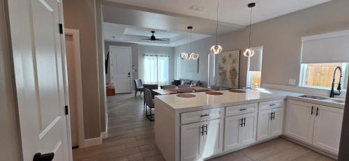 a kitchen with white cabinets and a dining room at Lux Modern 3BR - 2BA Duplex Brand New Furnished in Brownsville