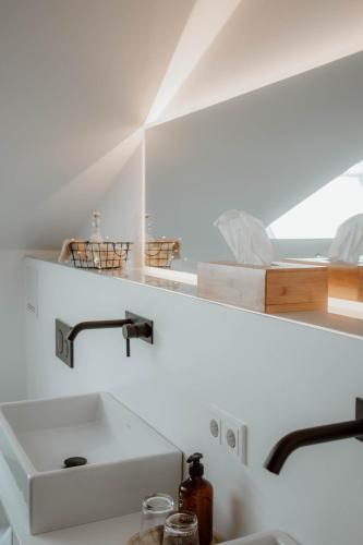 a kitchen with a sink and a mirror at Das Naturlich - Ruhiges Apartment Hotel nahe Regensburg in Sinzing