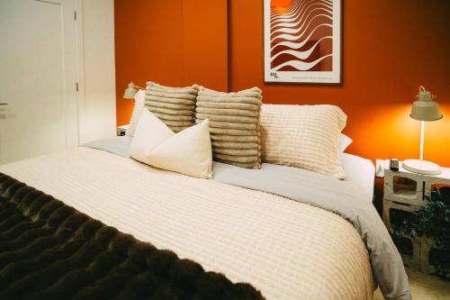 a bedroom with a large bed with orange walls at Historic Charming 2BR Apartment DT Halifax in Halifax