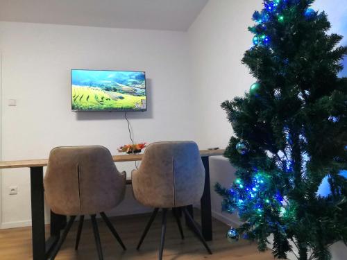 een eetkamer met een kerstboom en twee stoelen bij Schöne Wohnung am Bahnhof Schwerte in Schwerte