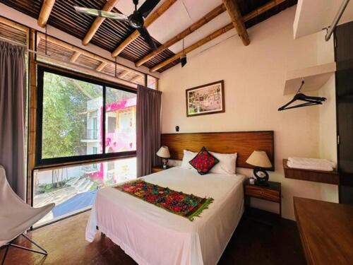 een slaapkamer met een bed en een groot raam bij Los Suspiros Hotel Boutique & Spa in Comala