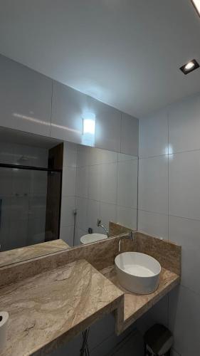 a bathroom with a counter with a sink and a mirror at Studio moderno Alu lounge 103 in São Luís