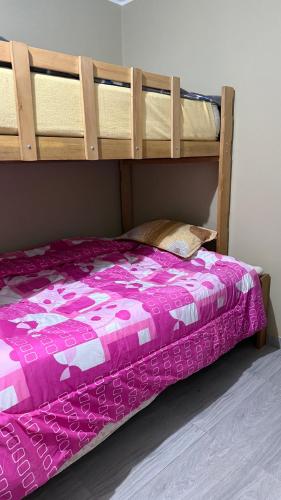 a bedroom with a bunk bed with a purple comforter at Habitación Los Solises in Jauja