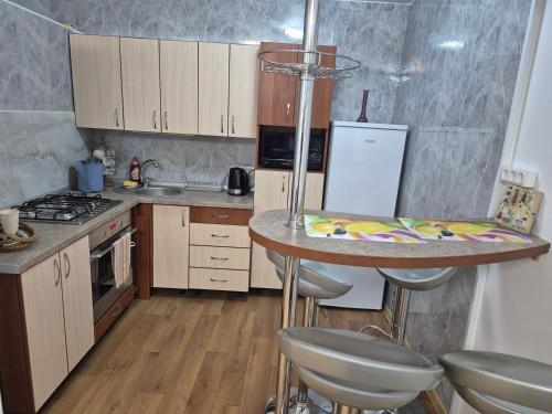 eine Küche mit einer Theke und einem Tisch darin in der Unterkunft Cozy Žemaitės gatvė in Telšiai