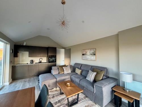 een woonkamer met een bank en een tafel bij Beyond The Waters Edge Chalet in Dooagh