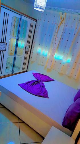 a bed in a room with purple pillows on it at le riffe in Nador