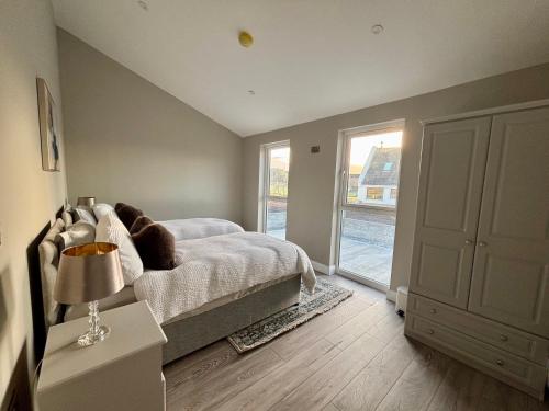 een slaapkamer met een bed en een raam bij Beyond The Waters Edge Chalet in Dooagh