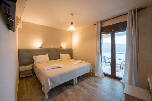 a bedroom with a bed and a balcony at PORTO TIMONI in Afionas
